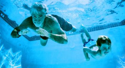 A grandad and grandson in the pool